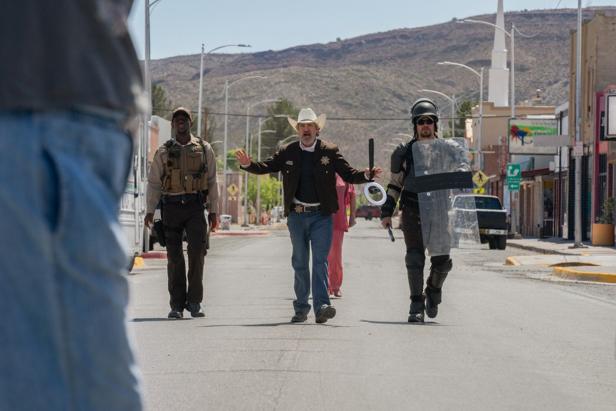 Joaquin Phoenix as the sheriff tries to break up a demonstration with his two officers