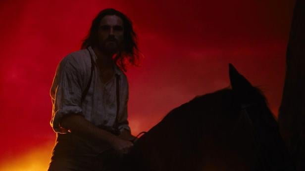 Jabod Elordi on horseback in front of a fiery red sky