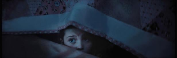 Sophie Sloan peeks out from under a blanket