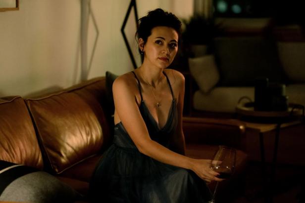Jessica Henwick sits on the couch in a film role