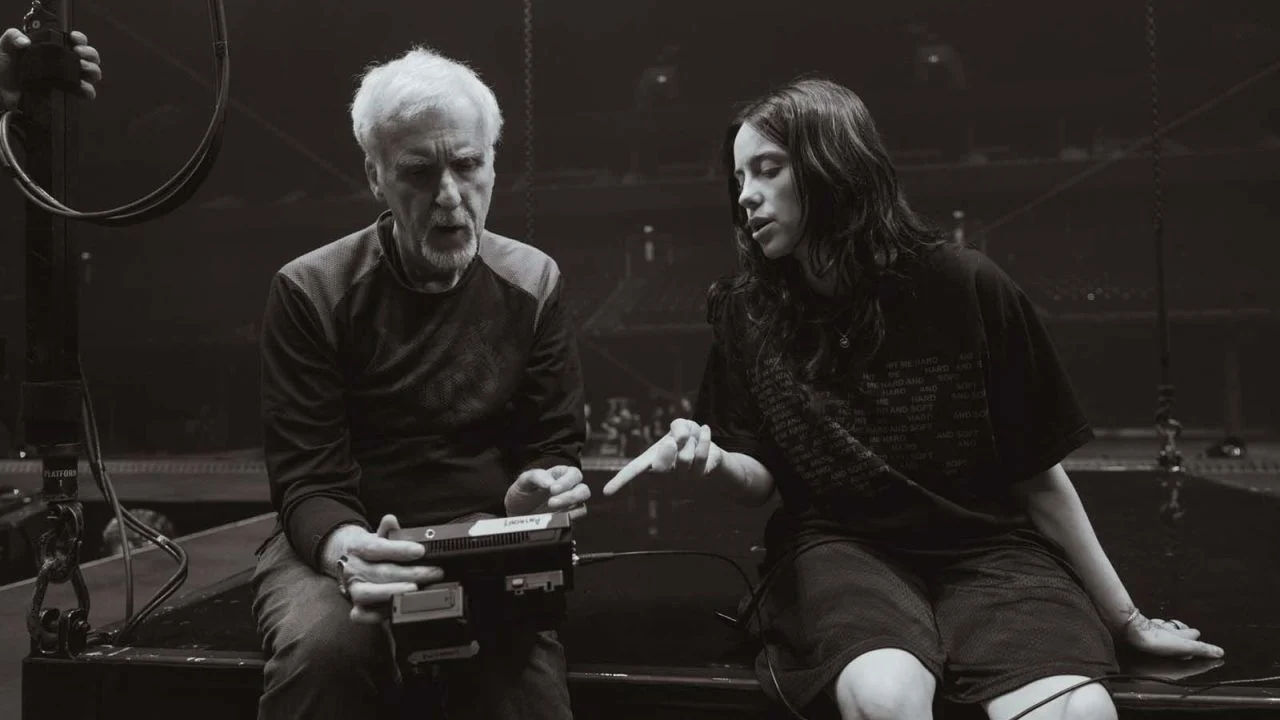 Two world stars together: James Cameron and Billie Eilish go over the filming schedule for the concert the following evening.