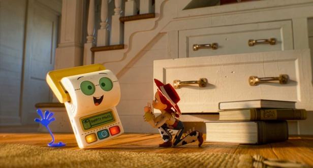 Jessie from Toy Story kneels on a wooden floor in front of the talking toy Smarty Pants.