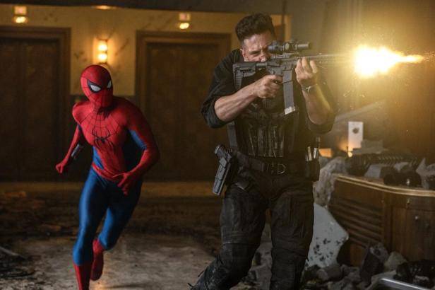 Spider-Man runs alongside the Punisher, who is firing a rifle.