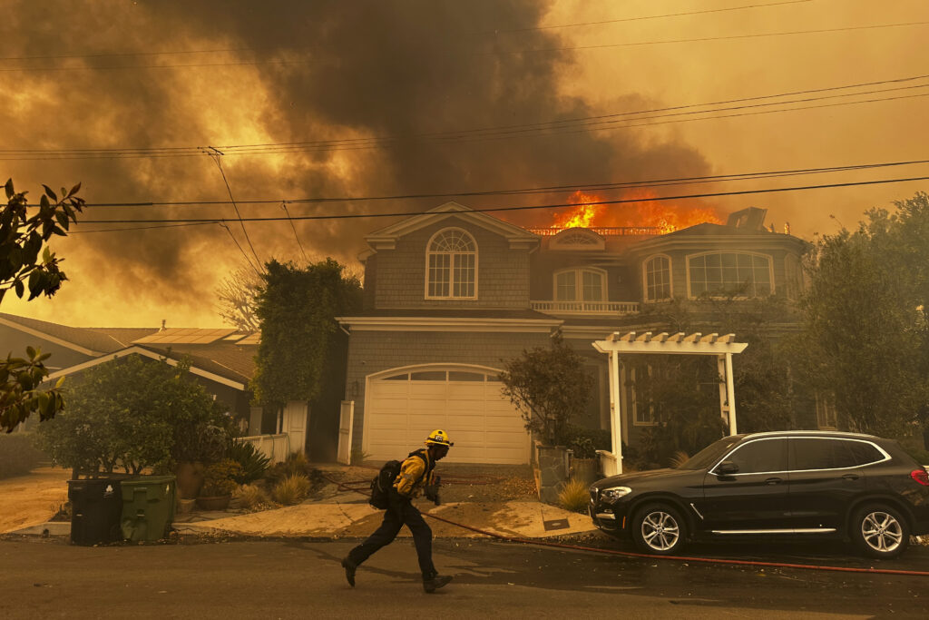Los Angeles residents flee as wind-fueled fire advances