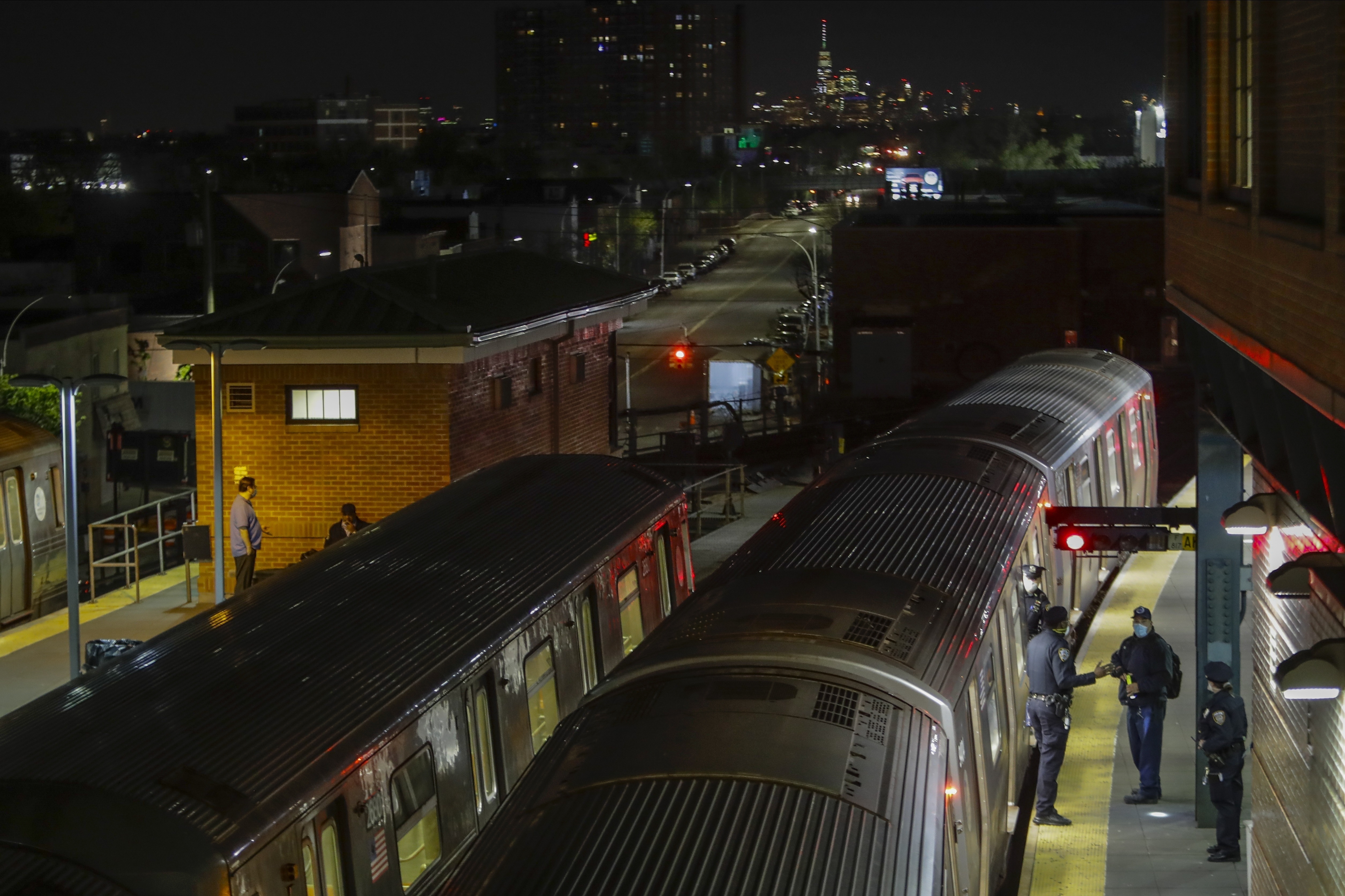 FILE - NYPD officers empty a train at the Coney Island-Stillwell Avenue terminal on May 5, 2020, in the Brooklyn borough of New York.