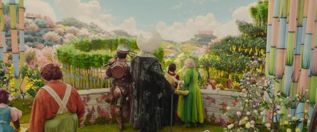 Several figures look out from a stone balcony into a colorful, fairytale world