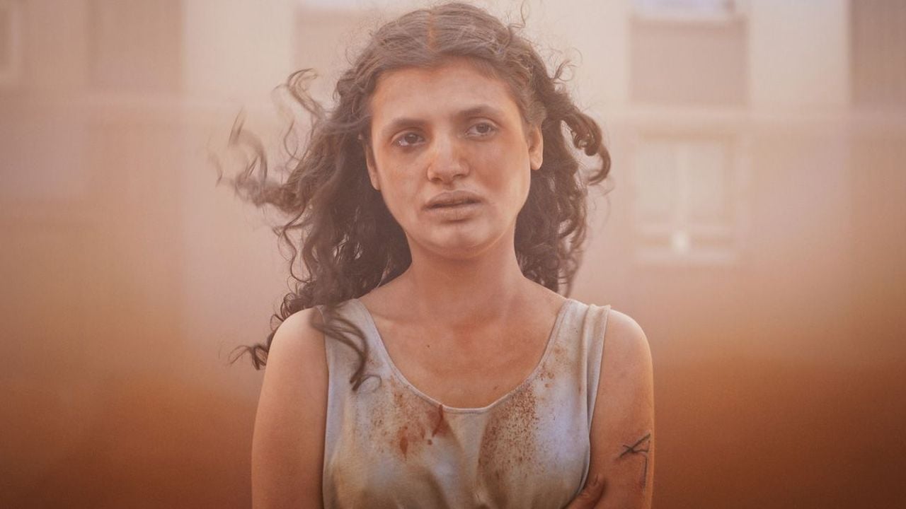 In the middle of a desert sandstorm, Alpha (Mélissa Boros) rolls down the cheek a single red tear.